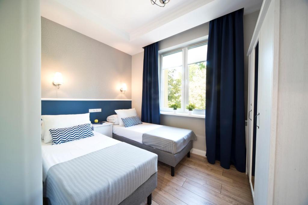 比亚韦斯托克Rint - Centrum Grochowa Street的酒店客房设有两张床和窗户。