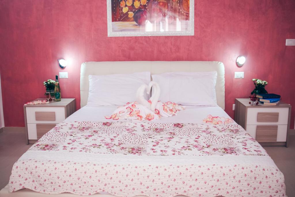 乌真托Il Sorriso B&B的卧室配有白色的床铺和粉红色的墙壁