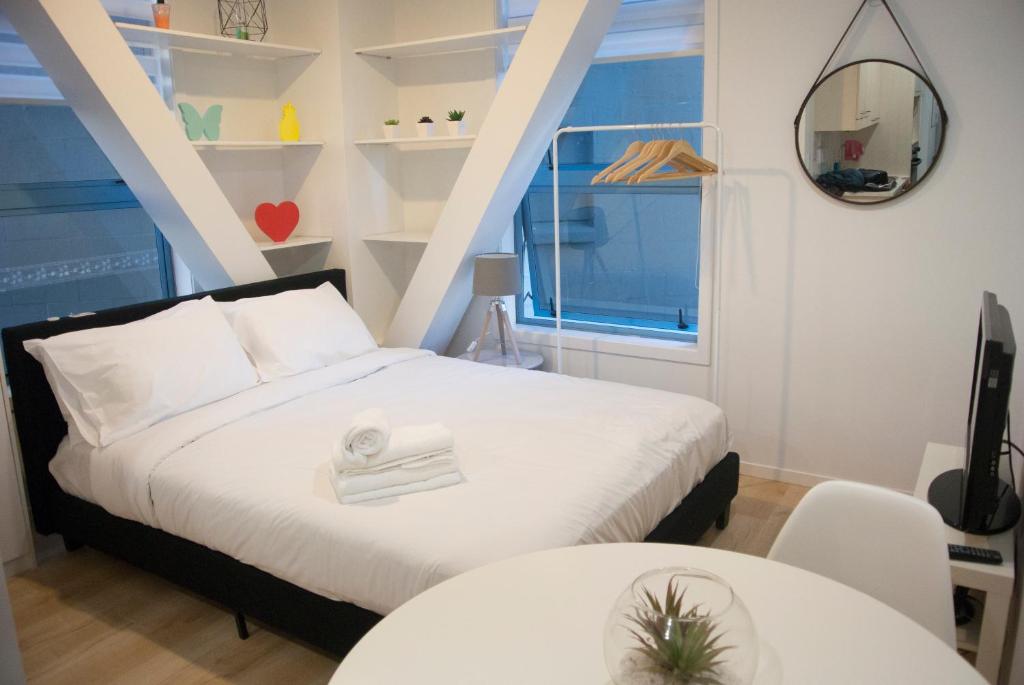 奥克兰市中心舒适公寓的一间卧室设有床、两张桌子和一扇窗户