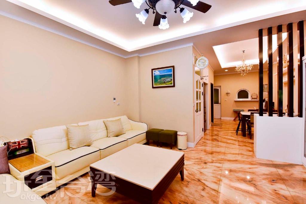 马公星乐民宿 的客厅配有白色的沙发和桌子