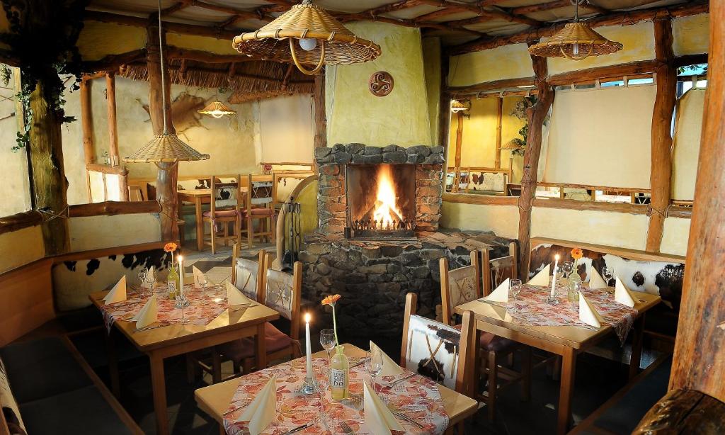 SünnaKelten-Hotel的一间带2张桌子和壁炉的餐厅