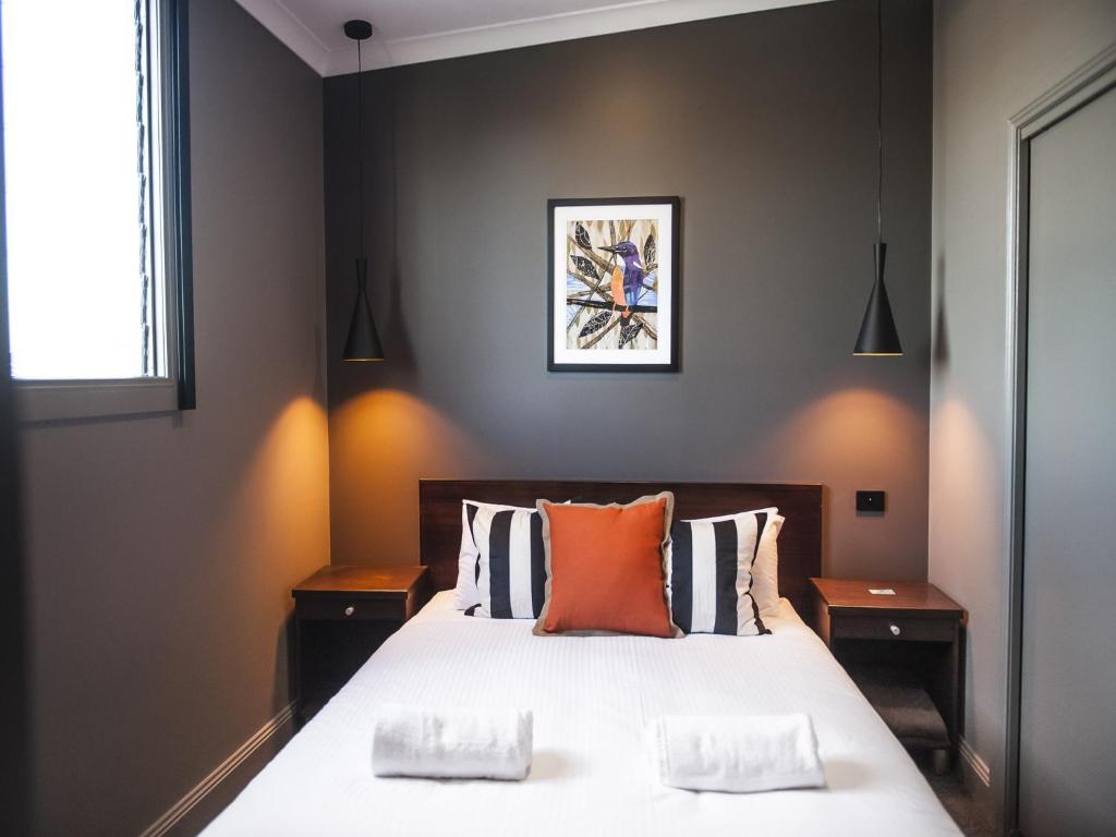 瑟尔Criterion Hotel Sale的一间卧室配有一张带橙色枕头的大床