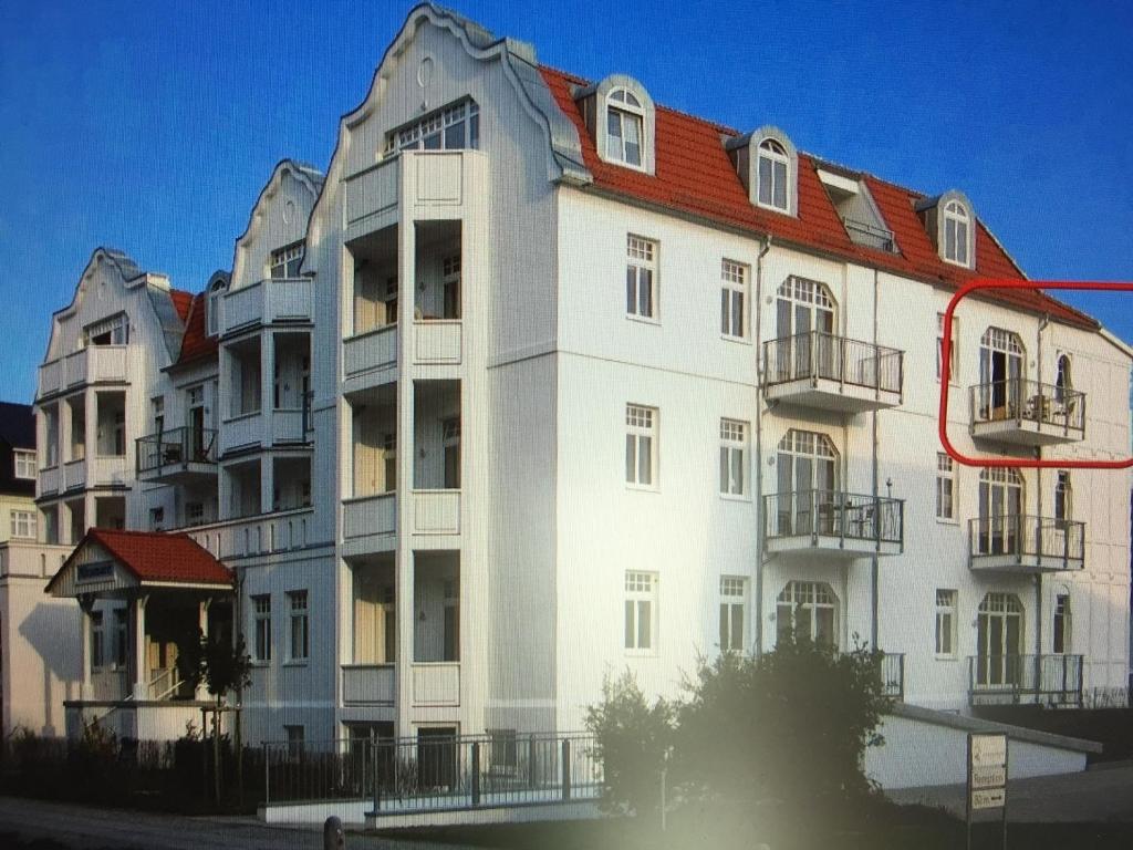 奥斯赛拜-屈隆斯博恩Miramare Wohnung 24的一座白色的大建筑,有红色的屋顶