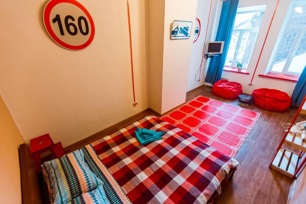 符拉迪沃斯托克VVO中心公寓的卧室配有一张床铺,房间墙上有标志