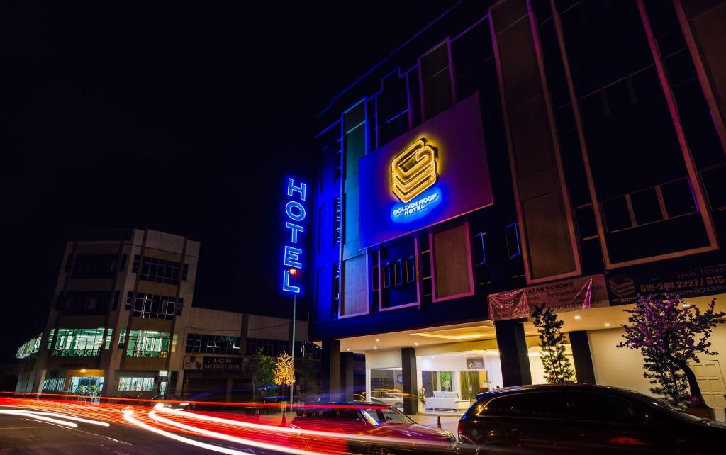 怡保Golden Roof Hotel Ampang Ipoh的夜间建筑物一侧的标志