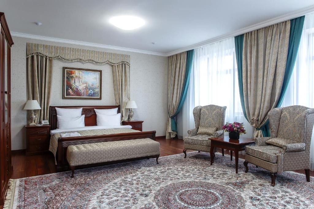 阿斯塔纳阿兰达酒店的酒店客房,配有一张床和两把椅子