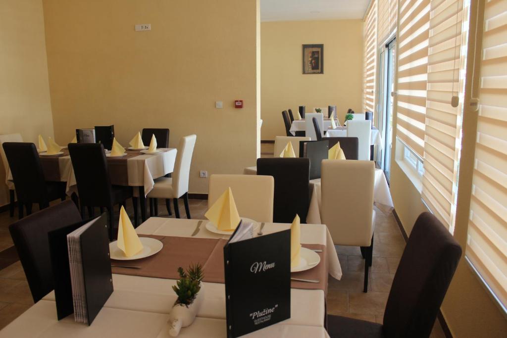 普卢日内Guesthouse Eko Piva的用餐室配有桌子和白色的椅子以及桌子。