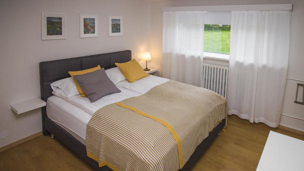 塞尔福斯19号公寓的一间卧室配有一张带黄色枕头的床和一扇窗户