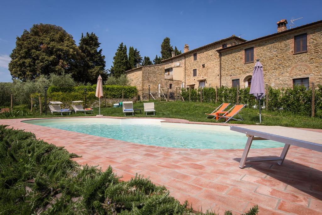 基亚恩尼Borgo Pie' di Gamboi的一座带椅子和遮阳伞的游泳池位于一座建筑旁边