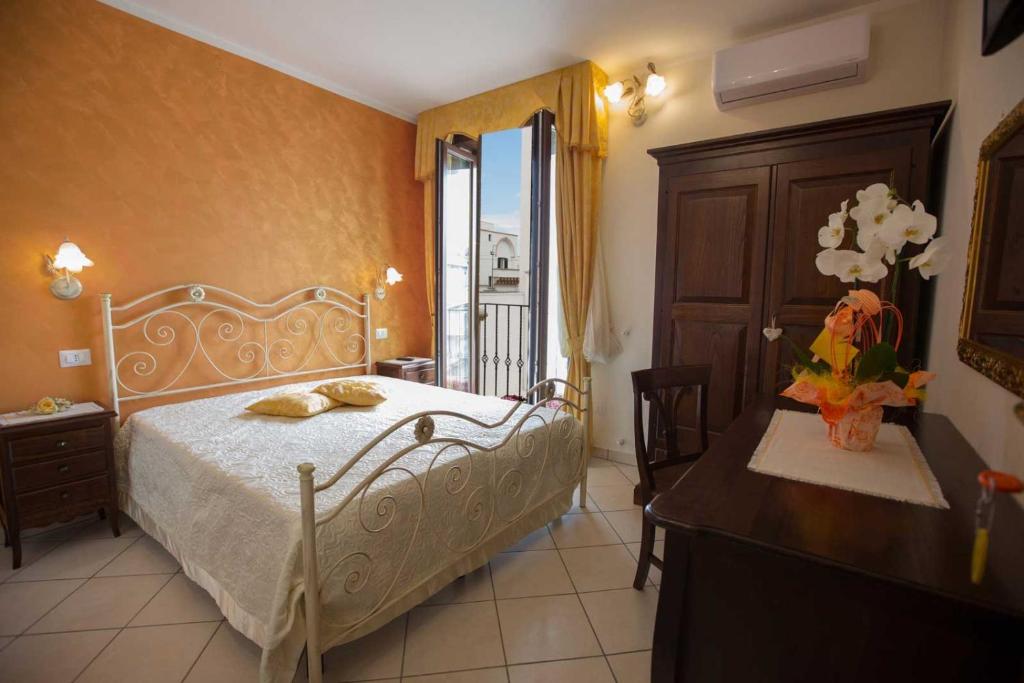 塔维亚诺B&B Le due gioie的一间卧室配有一张床、一张桌子和一个窗户。