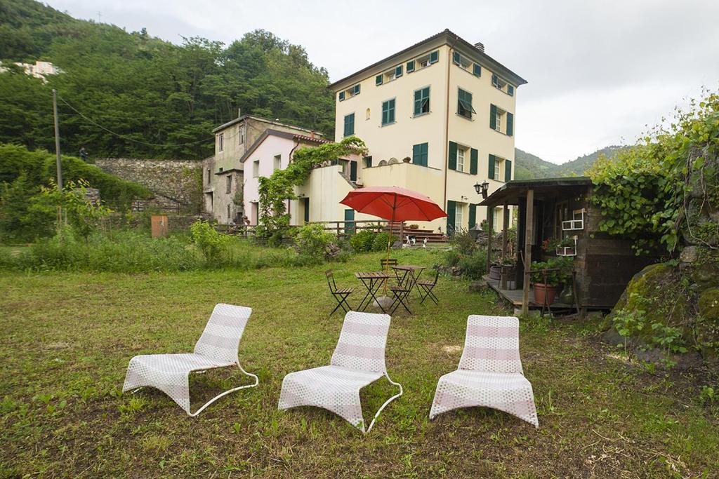 NeCà di Gatti Guesthouse的四把白色椅子和一张桌子,一座建筑