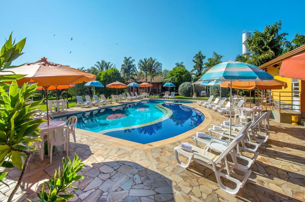 阿蒂巴亚帕约尔宾馆的一个带白色椅子和遮阳伞的游泳池