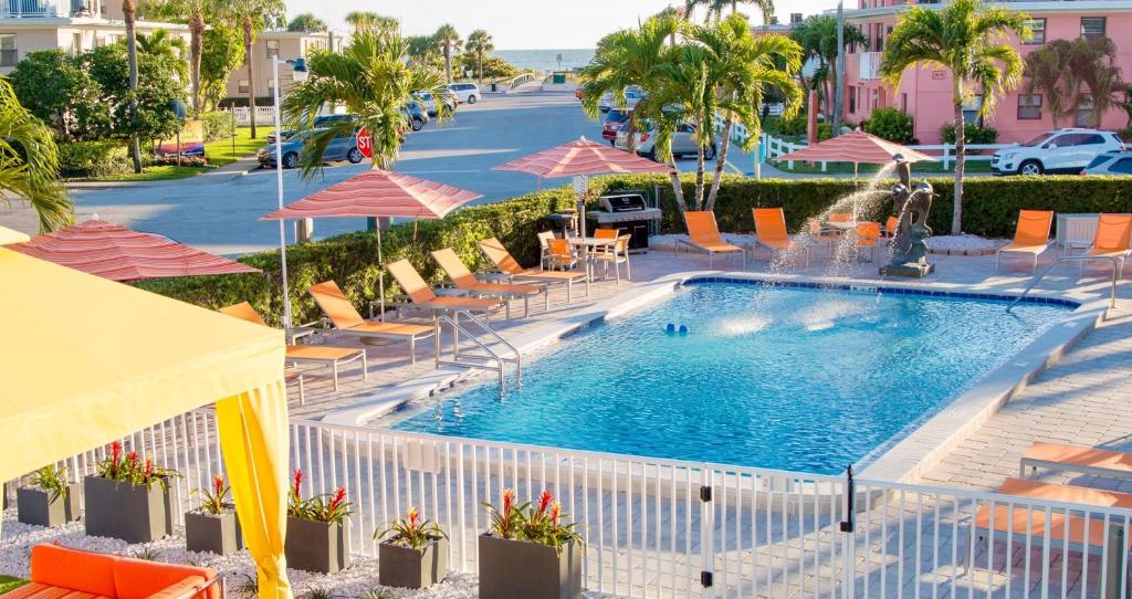 圣徒皮特海滩圣皮特海滩套房酒店的街边带椅子和遮阳伞的游泳池