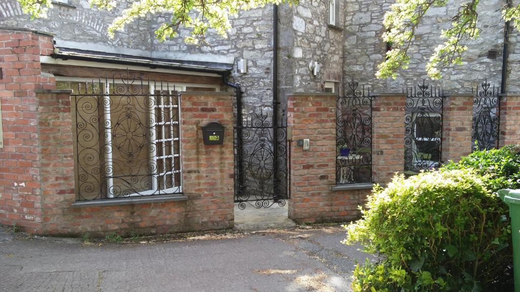 科克Historic Hideaway in Cork City Centre的带有铁门的砖砌建筑的入口