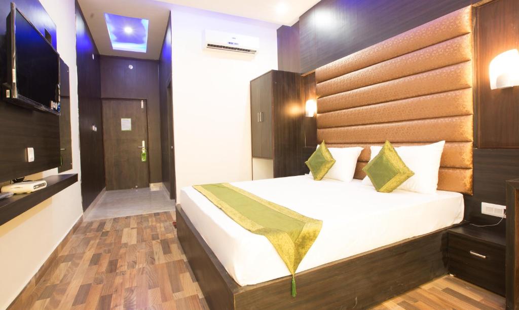 哈里瓦Vibhav Grand的一间卧室配有一张大床和电视