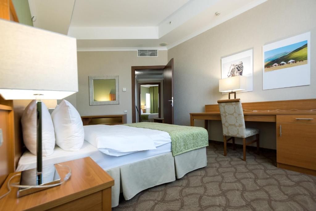阿斯塔纳杜门酒店的配有一张床和一张书桌的酒店客房