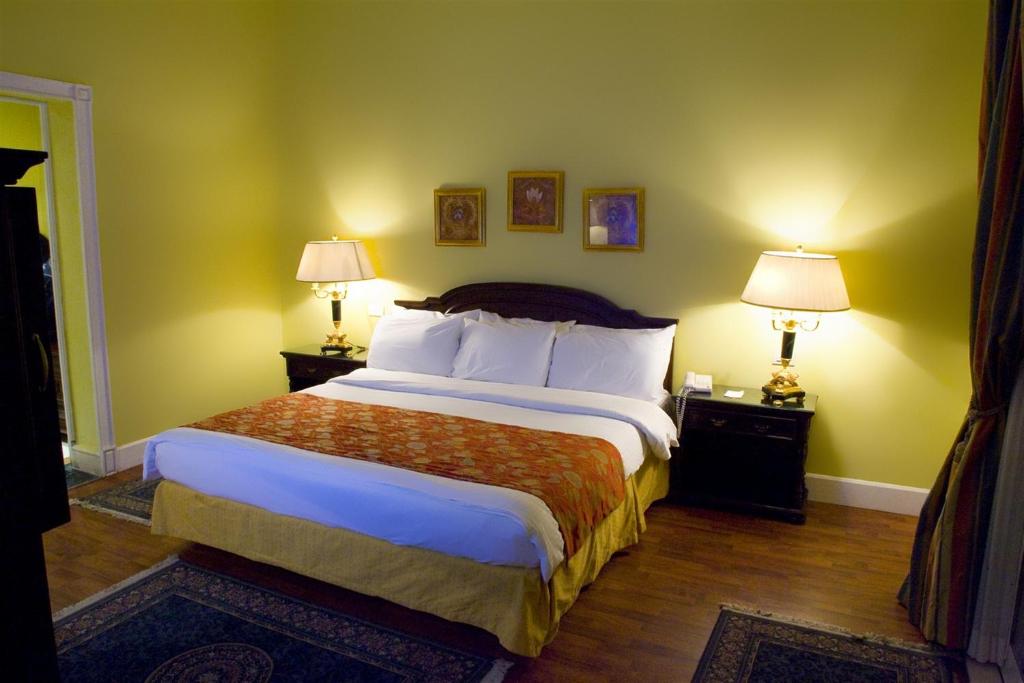 法尤姆法尤姆黑蓝旅馆的一间卧室配有一张大床和两个带灯的床头柜。