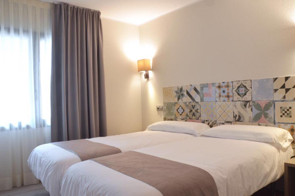 安道尔城图德尔酒店的酒店客房设有两张床和窗户。