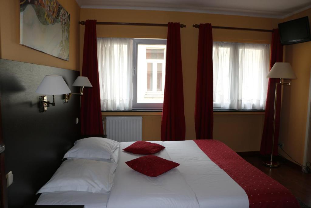布永Il Siciliano - Duc de Bouillon的一间卧室配有一张带两个红色枕头的床
