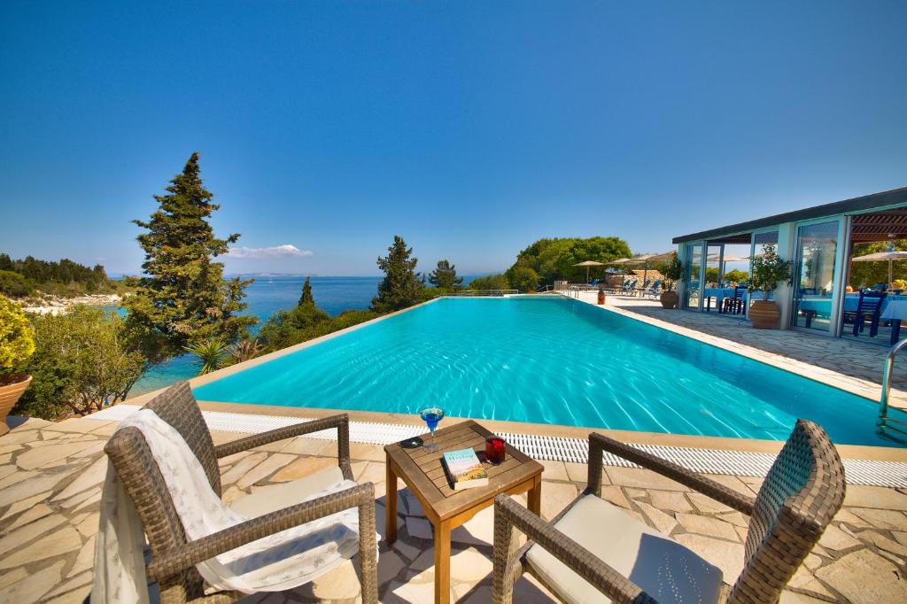 朗戈斯Glyfada Beach Villas的别墅 - 带游泳池、两把椅子和一张桌子