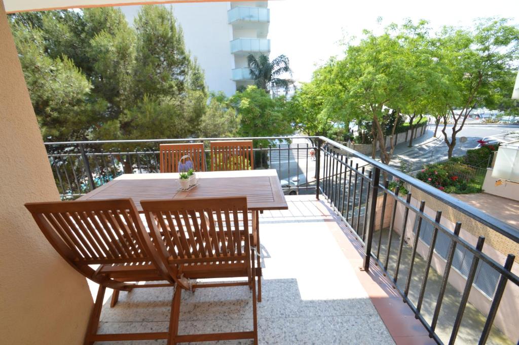 萨洛Apartamento Playa Capellans - Salou的阳台上的木桌和椅子