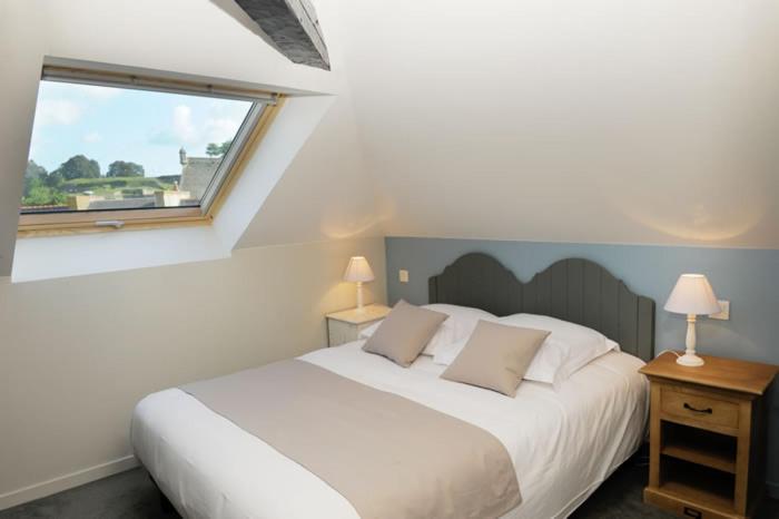 勒帕莱Hôtel Restaurant Corto Maltese的卧室设有一张白色大床和一扇窗户。
