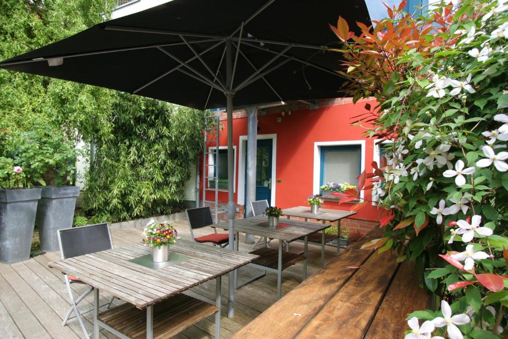 罗斯托克威尔第酒店的一个带桌椅和遮阳伞的庭院