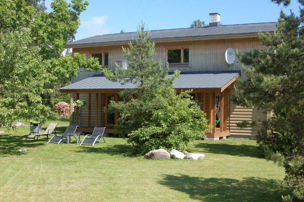 MuratsiKibuvitsa Holiday House的院子里的房屋,配有椅子和桌子