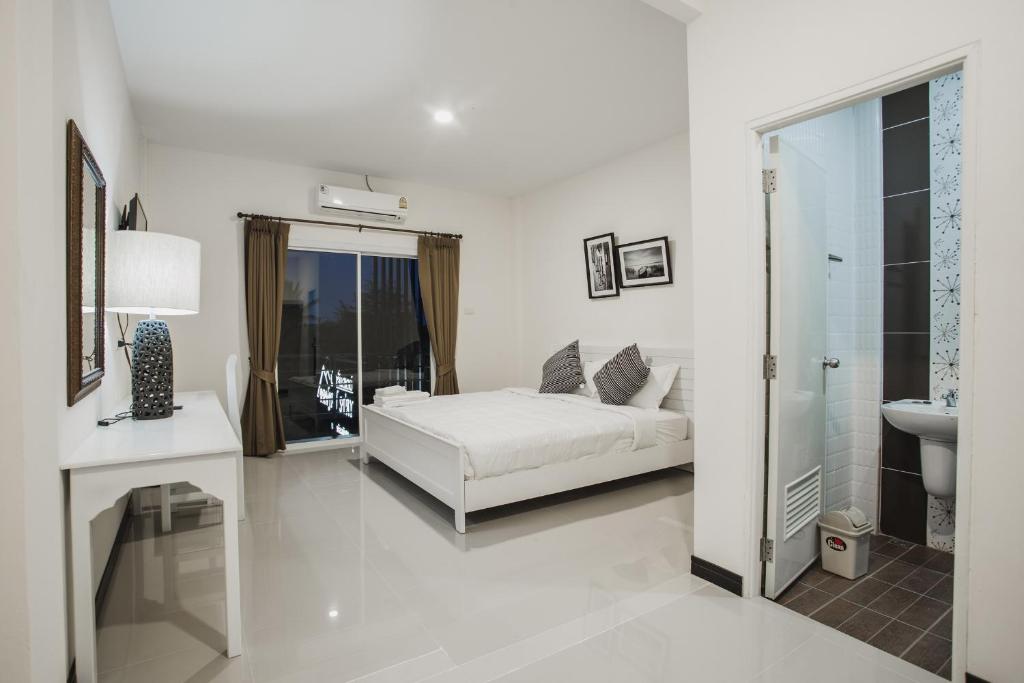 乌隆他尼班扬酒店的白色卧室设有床铺和水槽