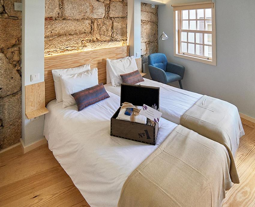 波尔图Chaves do Porto的一间卧室配有一张大床,上面有笔记本电脑