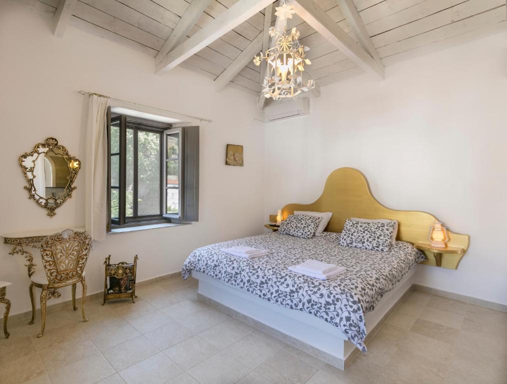伊兹拉Villa Sunrise的一间卧室配有一张床、一把椅子和一个吊灯。