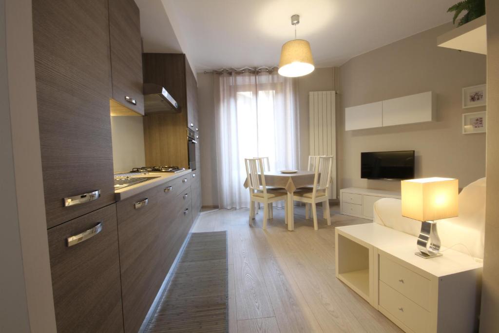 洛韦雷Appartamenti al Rizzo dei Santi的厨房以及带桌子和沙发的客厅。