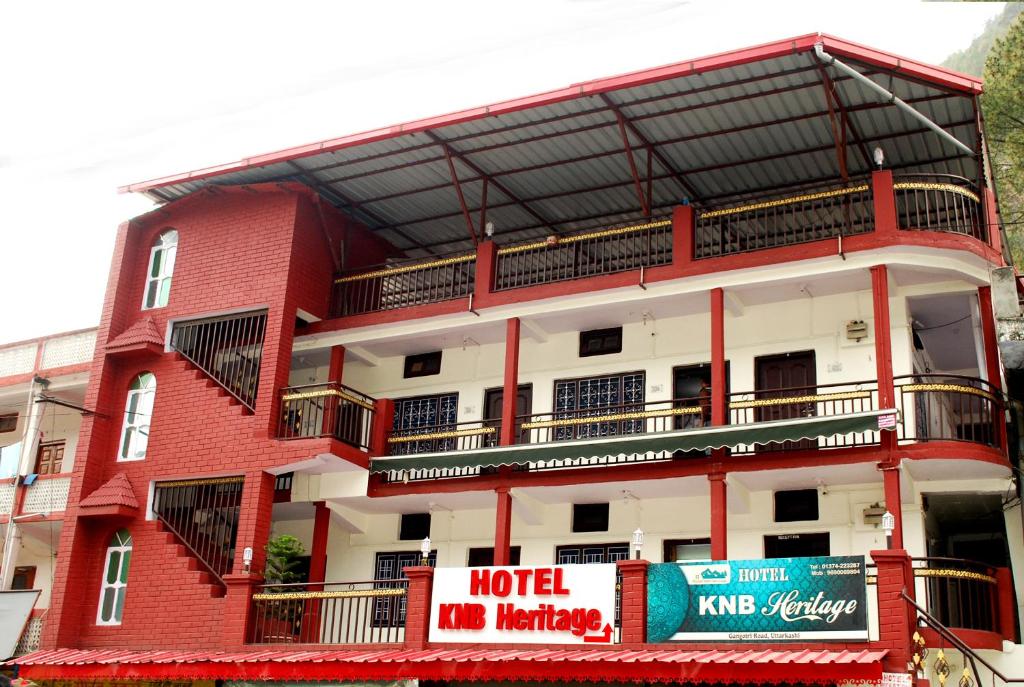 乌德尔格希Hotel KNB Heritage的一座红色和白色的建筑,前面有标志