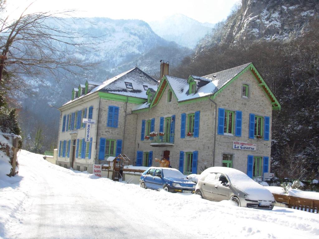 拉兰拉凯文纳酒店的一座有蓝色窗户的房子和停放在雪中的汽车