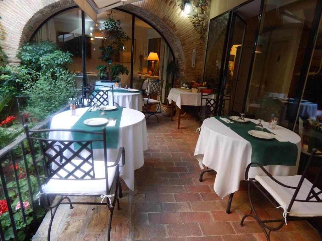 佩雷拉达德拉弗昂特佩尔拉达酒店的餐厅设有两张带绿色和白色桌布的桌子