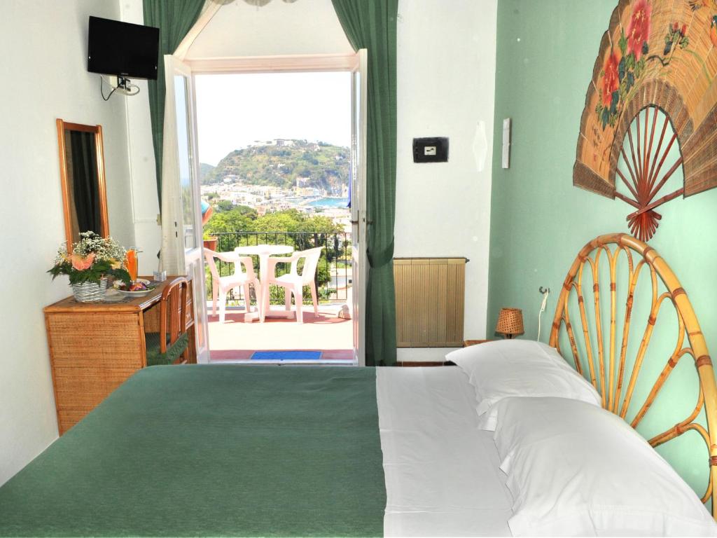 伊斯基亚Villa Raffaela B&B的一间带大床的卧室和一个阳台