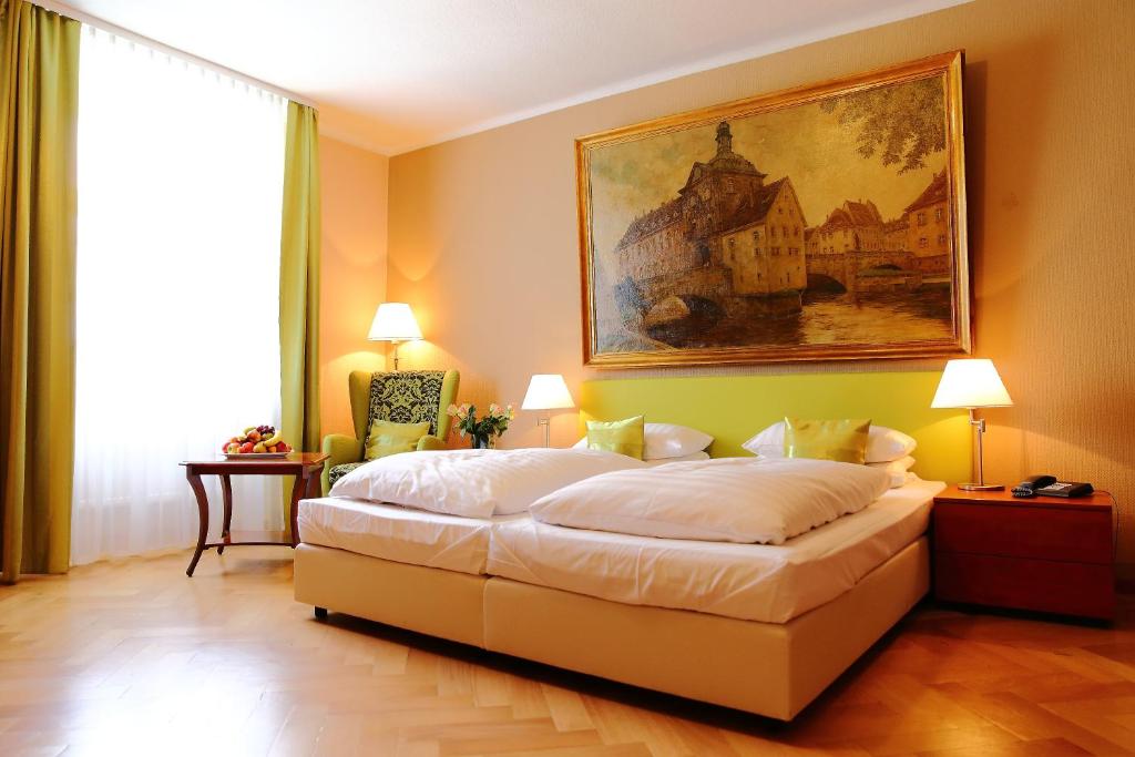 因戈尔施塔特拉蓬贝尔格酒店的卧室配有一张床,墙上挂有绘画作品