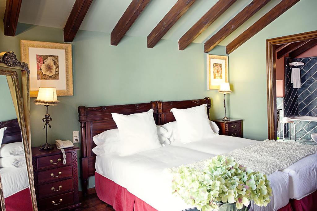 隆达蒙特利里欧酒店的一间卧室配有白色床单和鲜花。