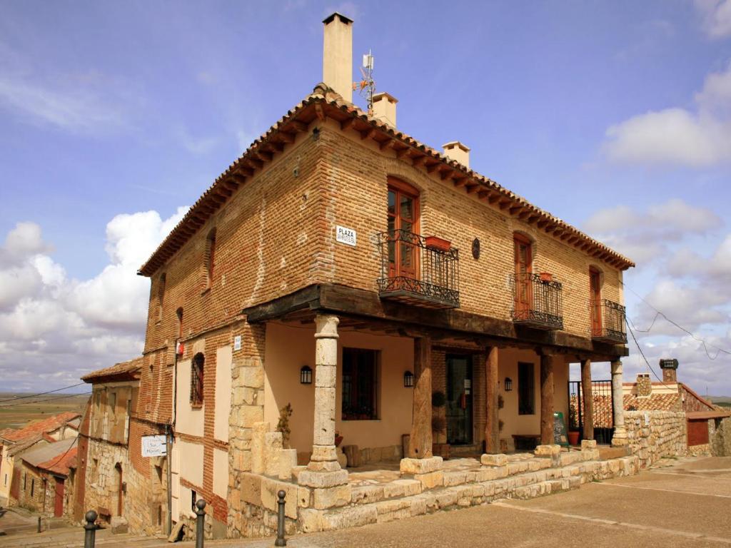Támara圣伊波利托乡村酒店的街道上一座旧砖砌建筑,设有阳台