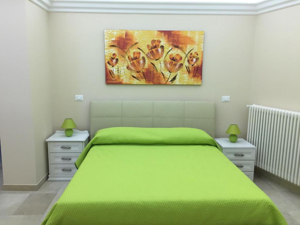帕拉比塔B&B Il Ventaglio的一间卧室配有一张绿色的床,墙上挂着一幅画