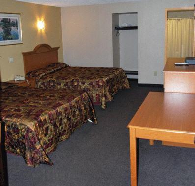 考皮格南湾汽车旅馆的酒店客房设有两张床和一张桌子。