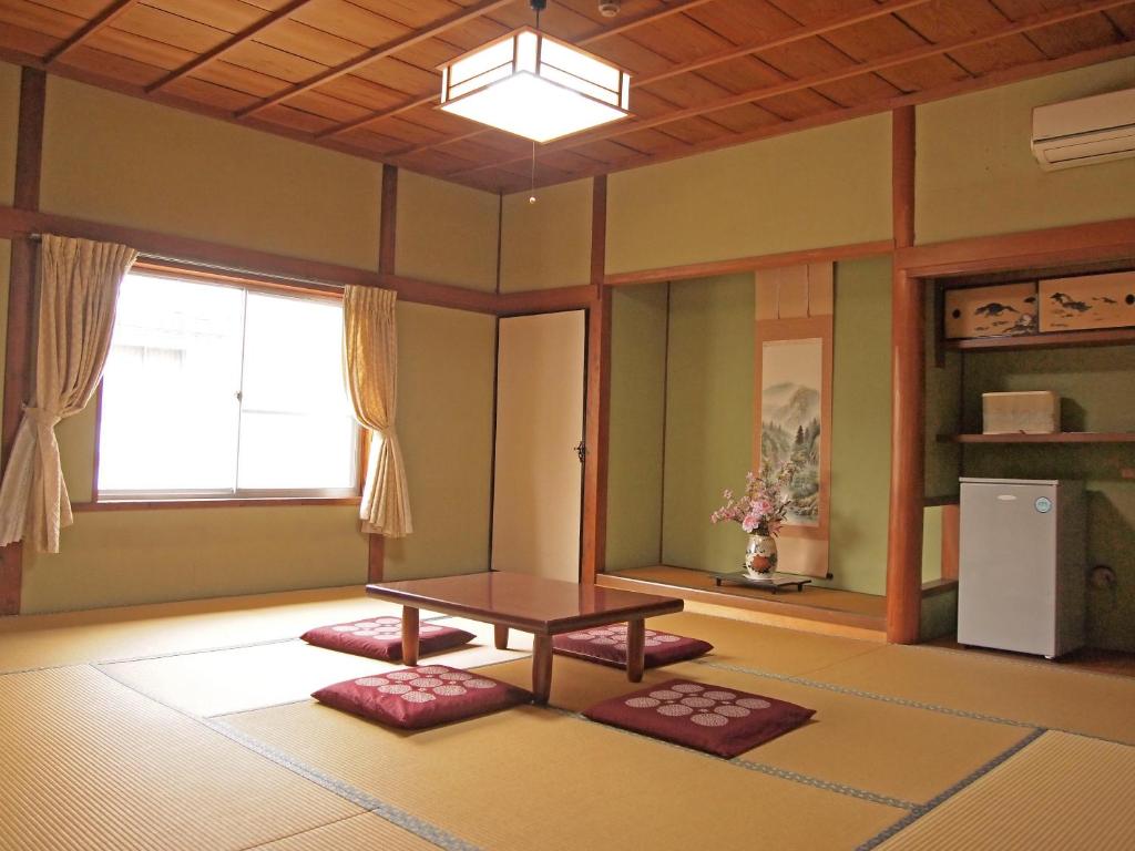 土庄町喜久屋日式旅馆的客厅配有桌子和窗户