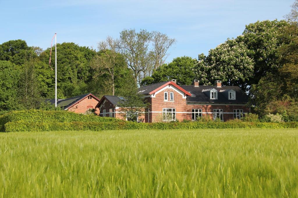 EdslevSkovlide Beautiful Farmhouse的一块大红砖房子,有一片草地