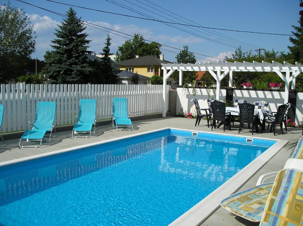 希欧福克Haus Sonnenhof的一个带桌椅的游泳池以及白色的围栏