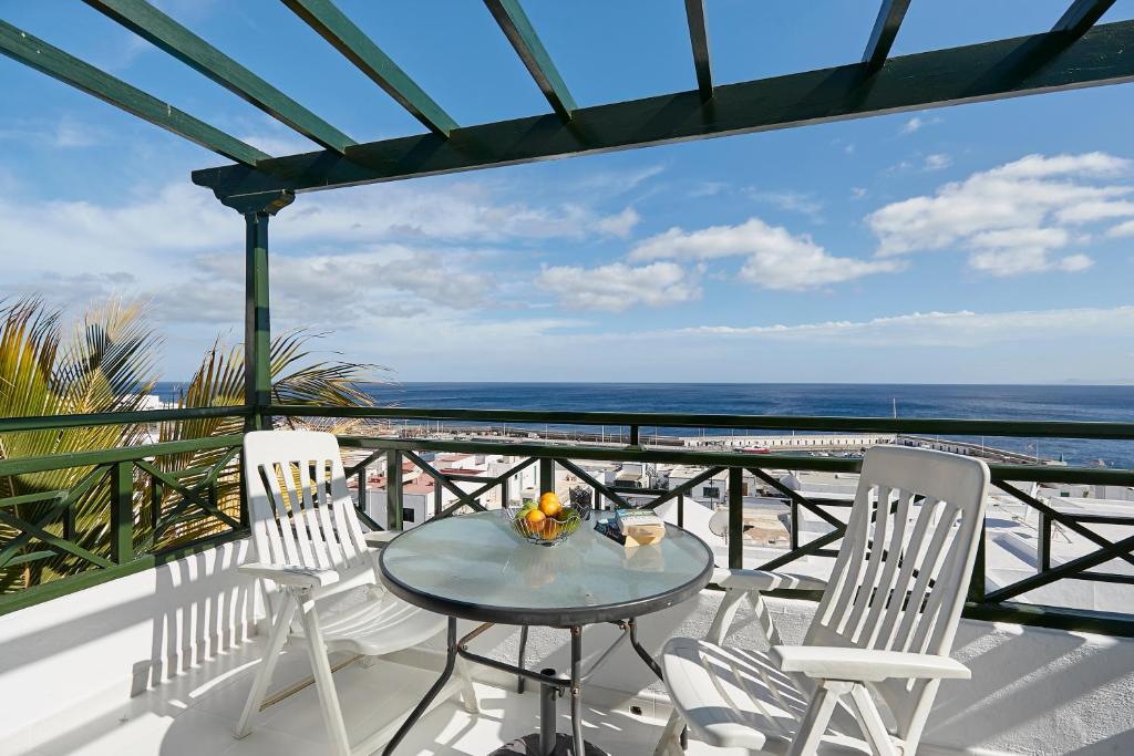 卡门港Knights Apartment的海滩阳台的桌椅