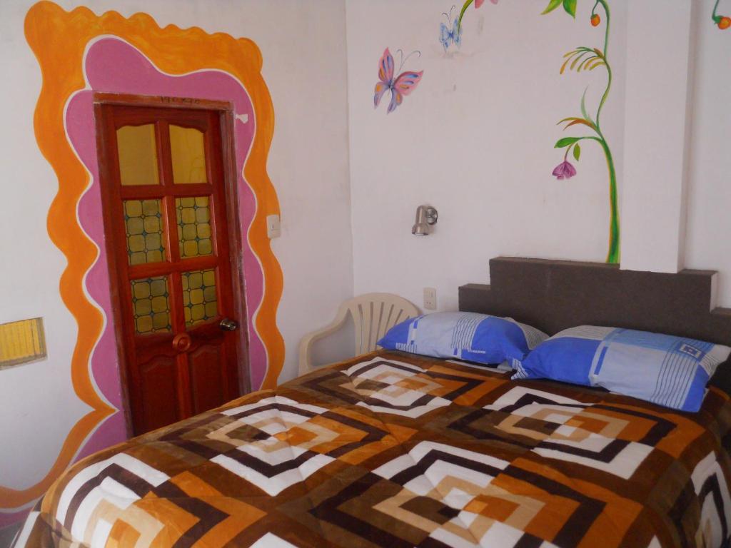 科帕卡巴纳Hostal La Casa del Sol的一间卧室配有一张带彩色床罩的床