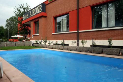 雷焦艾米利亚阿利罗尼酒店的大楼前的蓝色游泳池