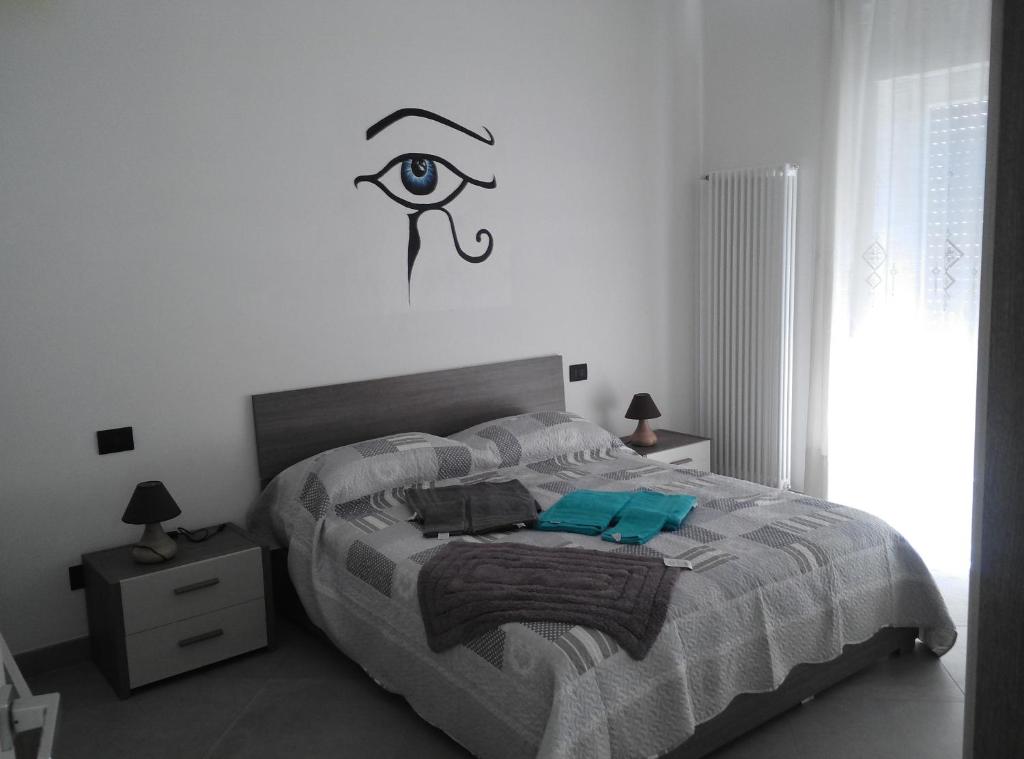 卢加尼亚诺Affittacamere Di Paola的卧室配有一张床铺,墙上有一眼