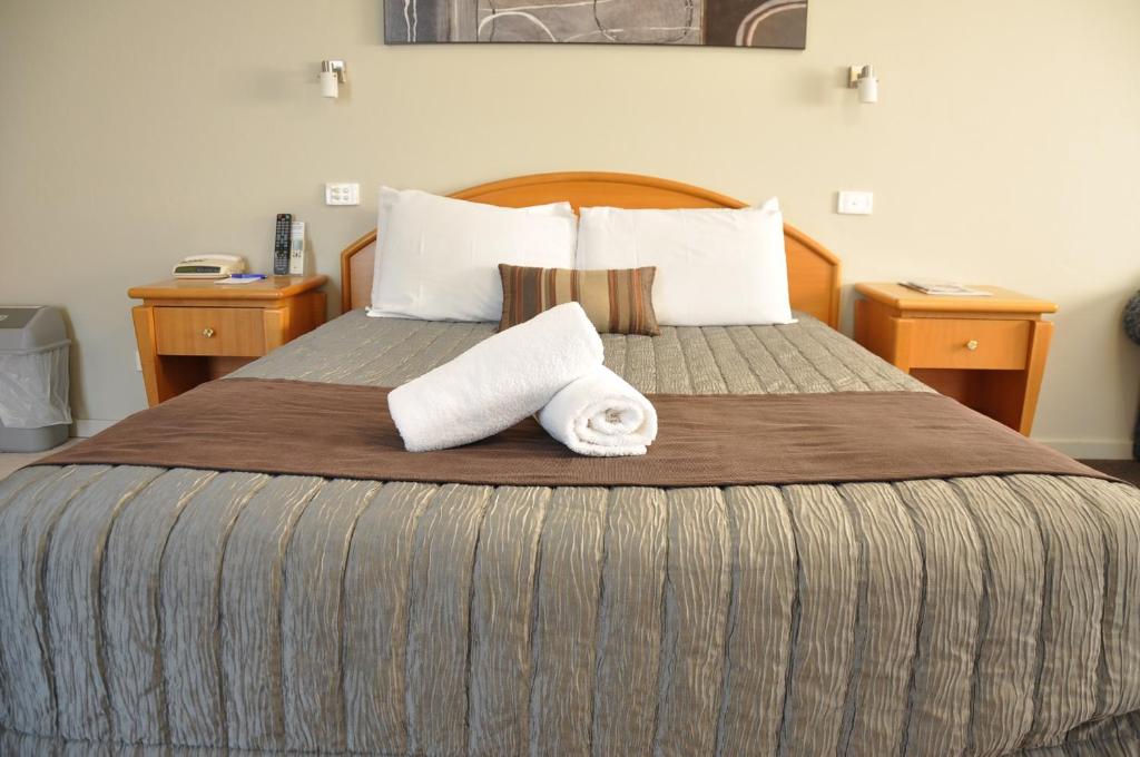 Tuggerah七塔维汽车旅馆的酒店客房,配有带两条毛巾的床