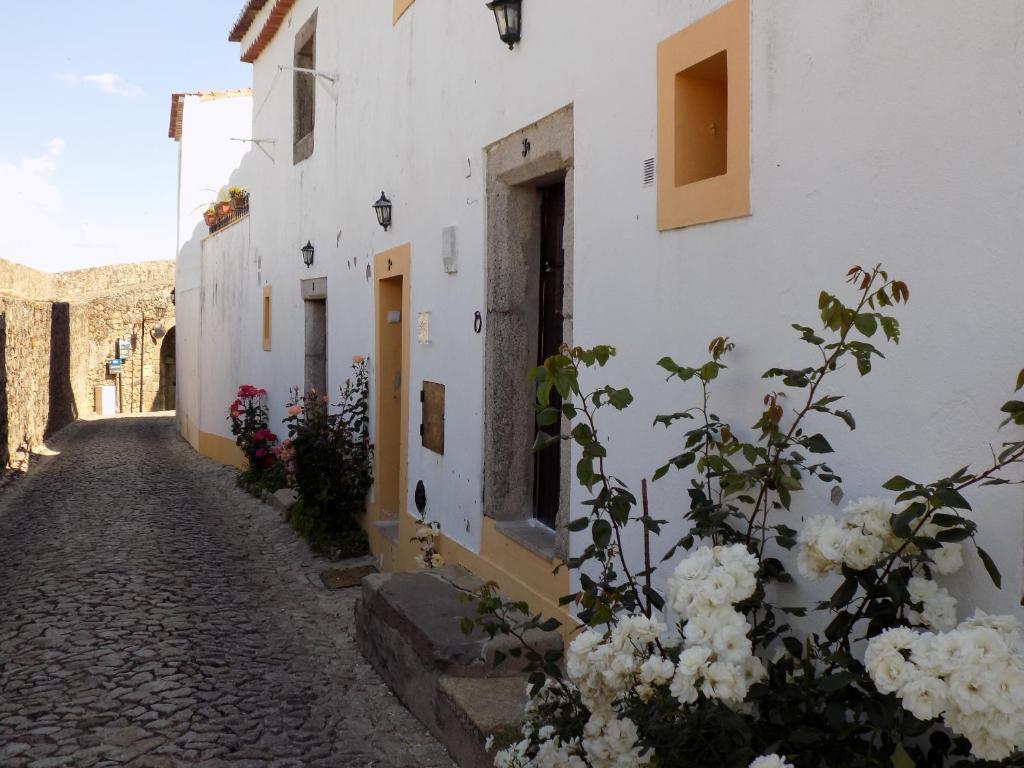 马尔旺Casa O Arco Alojamento Local的一条拥有白色建筑和鲜花的鹅卵石小巷